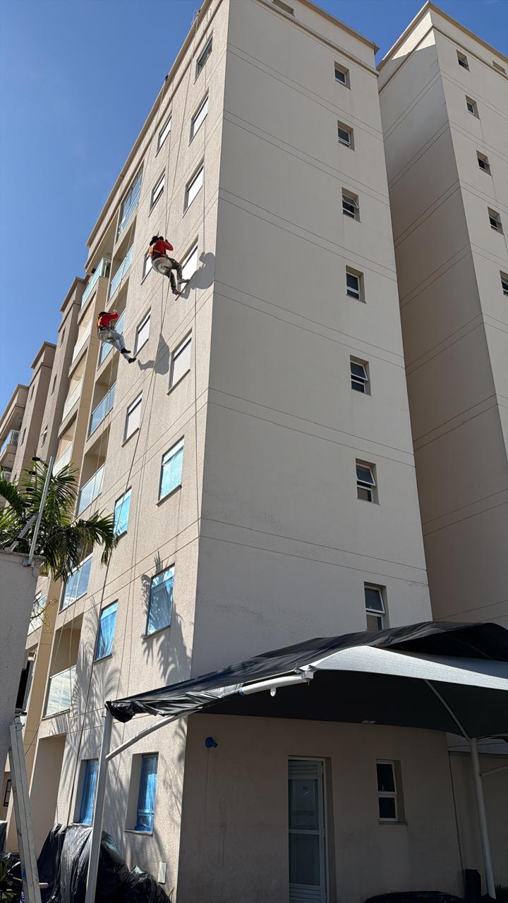 Profissionais da Minas executando pintura predial em altura